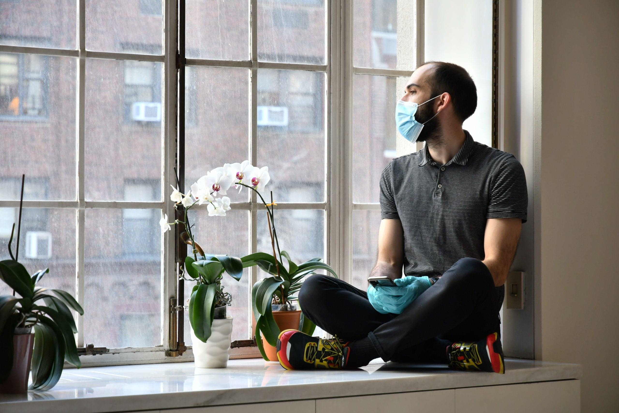 full-length-man-sitting-by-window-home